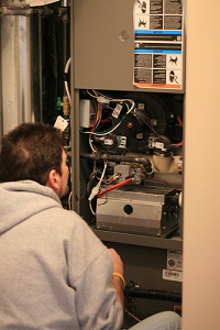 A technician repaiing a furnace. 