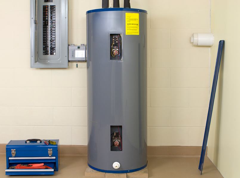 Electric water heater installed next to an electrical panel in a residential basement