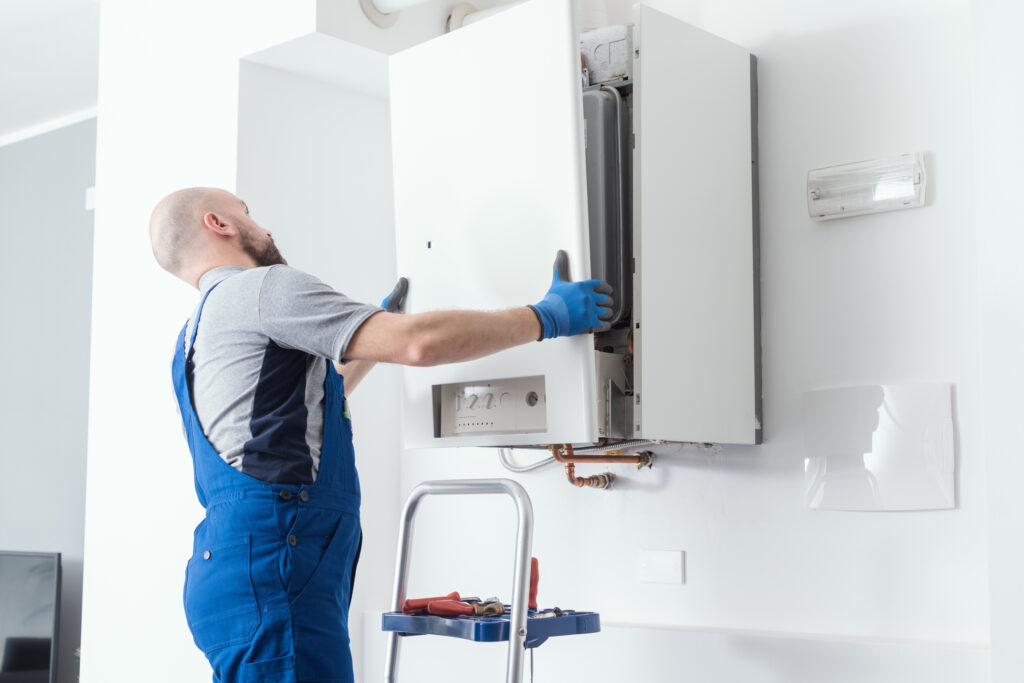 HVAC technician replacing the front faceplate of a residential boiler